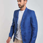 Man wearing a blue blazer, white t-shirt, and beige pants on a plain background