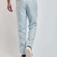 Man wearing light blue Dalydress trousers and beige shirt, rear view, casual menswear
