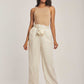 Woman wearing Dalydress beige sleeveless top and striped high-waisted pants, studio setting