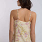Woman wearing Dalydress floral sleeveless top with yellow and pink print, back view
