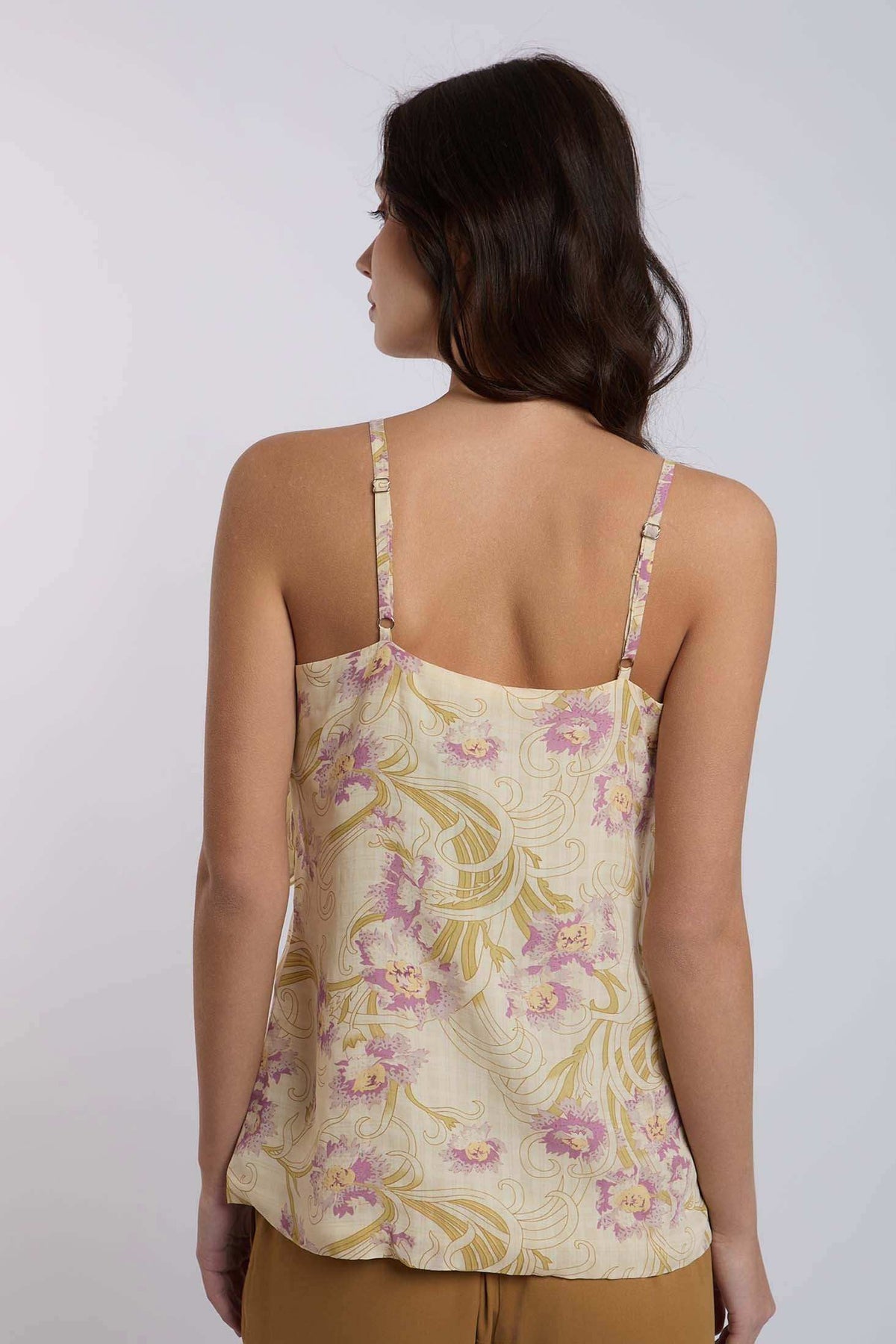 Woman wearing Dalydress floral sleeveless top with yellow and pink print, back view
