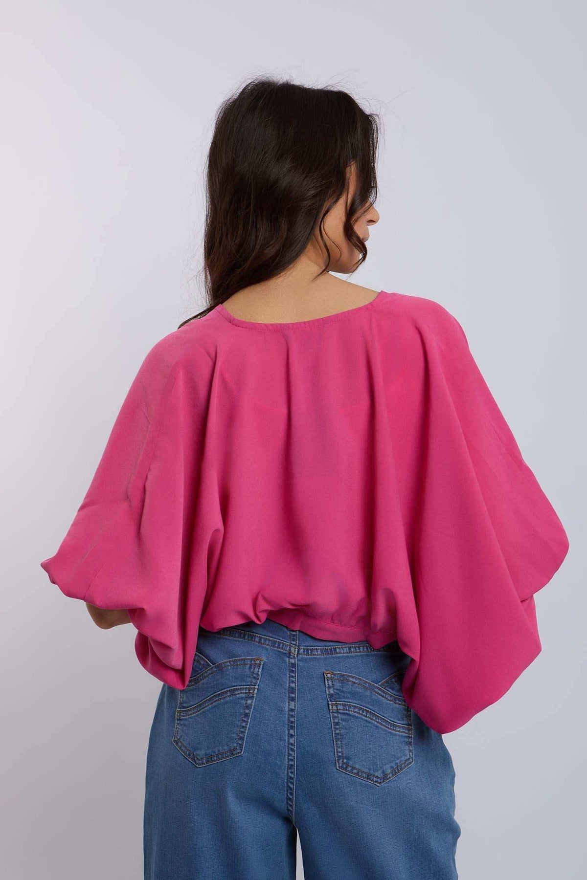 Woman in loose pink blouse and blue jeans, Dalydress casual women's fashion style