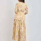 Woman wearing long-sleeve floral maxi dress in pastel yellow and pink by Dalydress