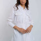 Woman modeling Dalydress white belted shirt with flap pockets and green pants, studio background