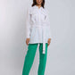 Woman wearing Dalydress white belted shirt and green pants, casual fashion look