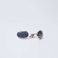 Oval silver cufflinks with dark blue geometric pattern on white background