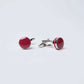 Pair of round red and silver cufflinks on a plain white background
