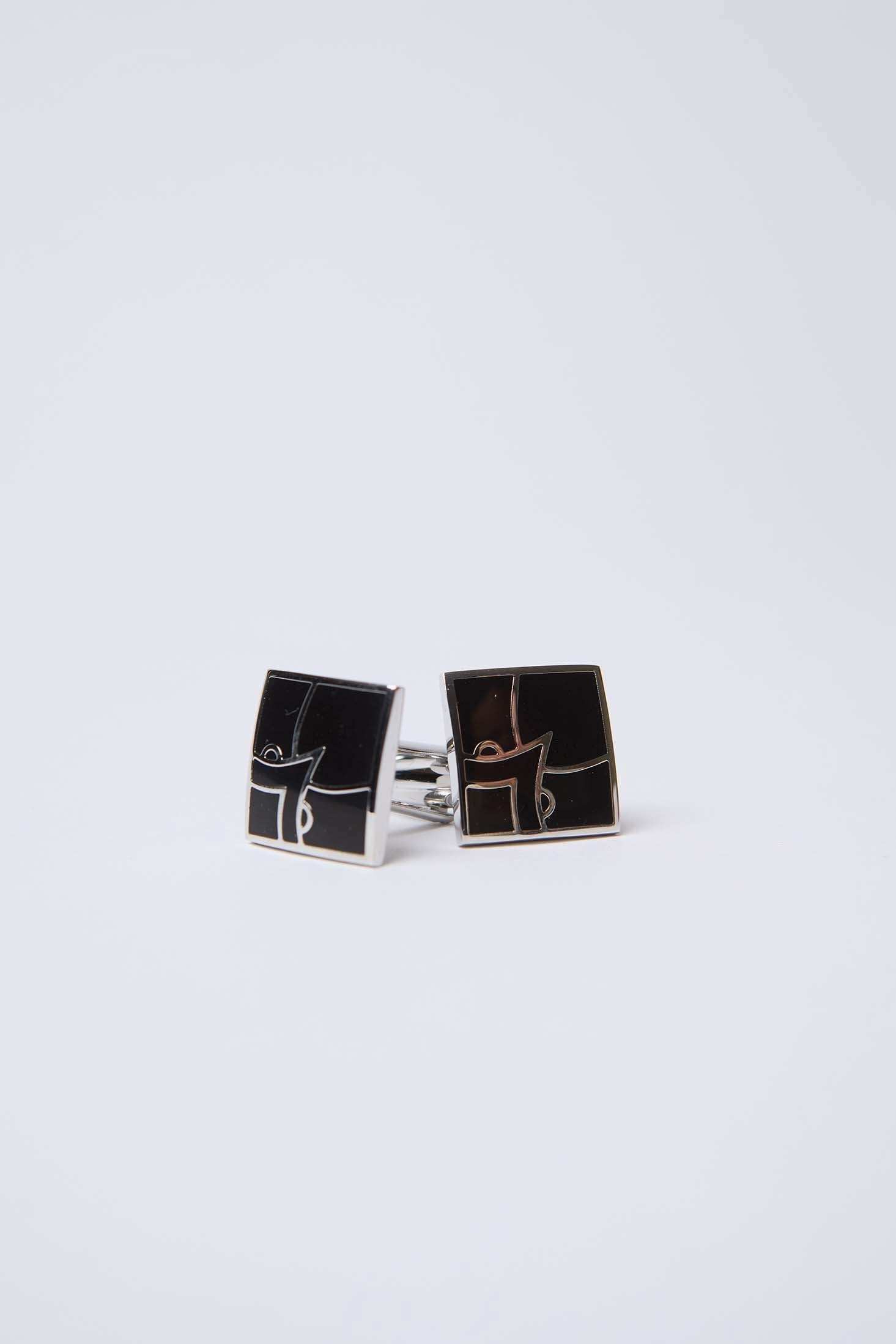 Square black and silver cufflinks with geometric design on white background