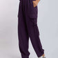 Woman wearing purple cargo pants with drawstring waist and white sneakers