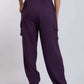 Woman wearing purple cargo jogger pants with elastic waistband and side pockets, back view