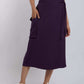 Woman wearing a purple wrap midi skirt with pocket and white crop top