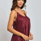 Woman modeling sleeveless burgundy satin top with spaghetti straps