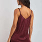 Woman wearing burgundy sleeveless V-neck top and matching pleated pants, back view