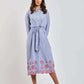 Woman wearing Dalydress blue striped shirt dress with pink floral embroidery, standing indoors