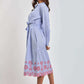 Woman wearing Dalydress blue striped shirt dress with red floral embroidery and belted waist