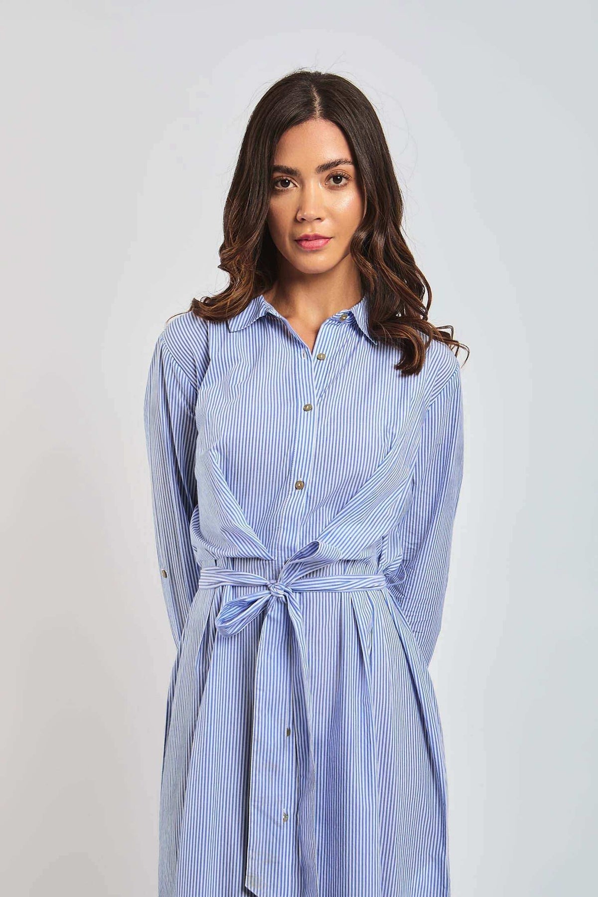 Woman wearing Dalydress blue striped shirt dress with waist tie, urban fashion style