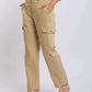 Woman wearing beige cargo pants with side pockets and strappy sandals