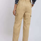 Woman wearing beige cargo pants with side pockets, back view, casual fashion style