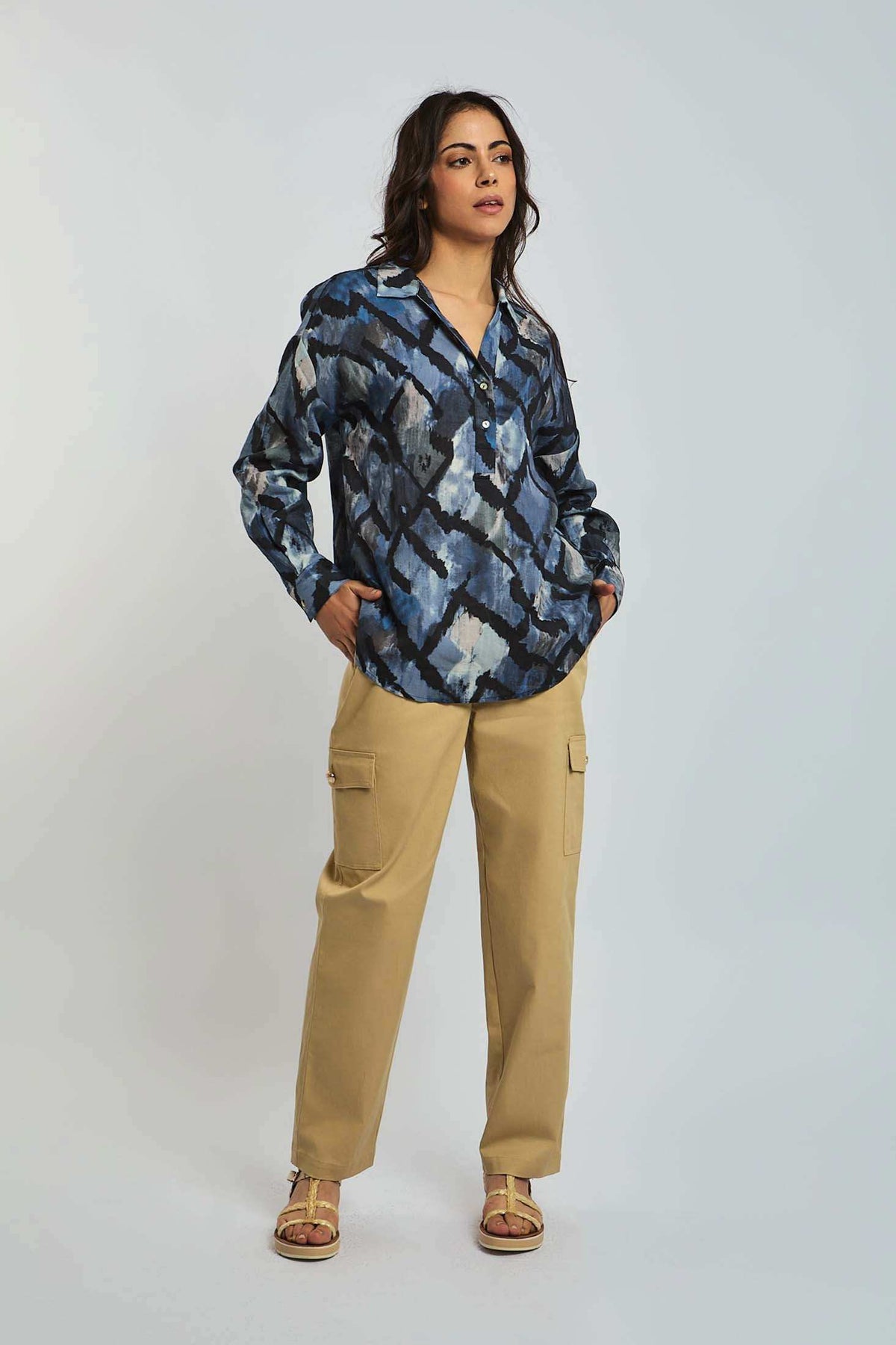 Woman wearing blue abstract print blouse and beige cargo pants, casual fashion look