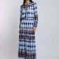 Woman wearing a long sleeve blue and white patterned maxi dress with braided sandals