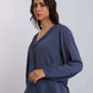 Woman wearing blue long sleeve V-neck blouse with embroidered trim