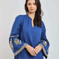 Woman wearing blue long-sleeve dress with gold embroidered patterns on the sleeves