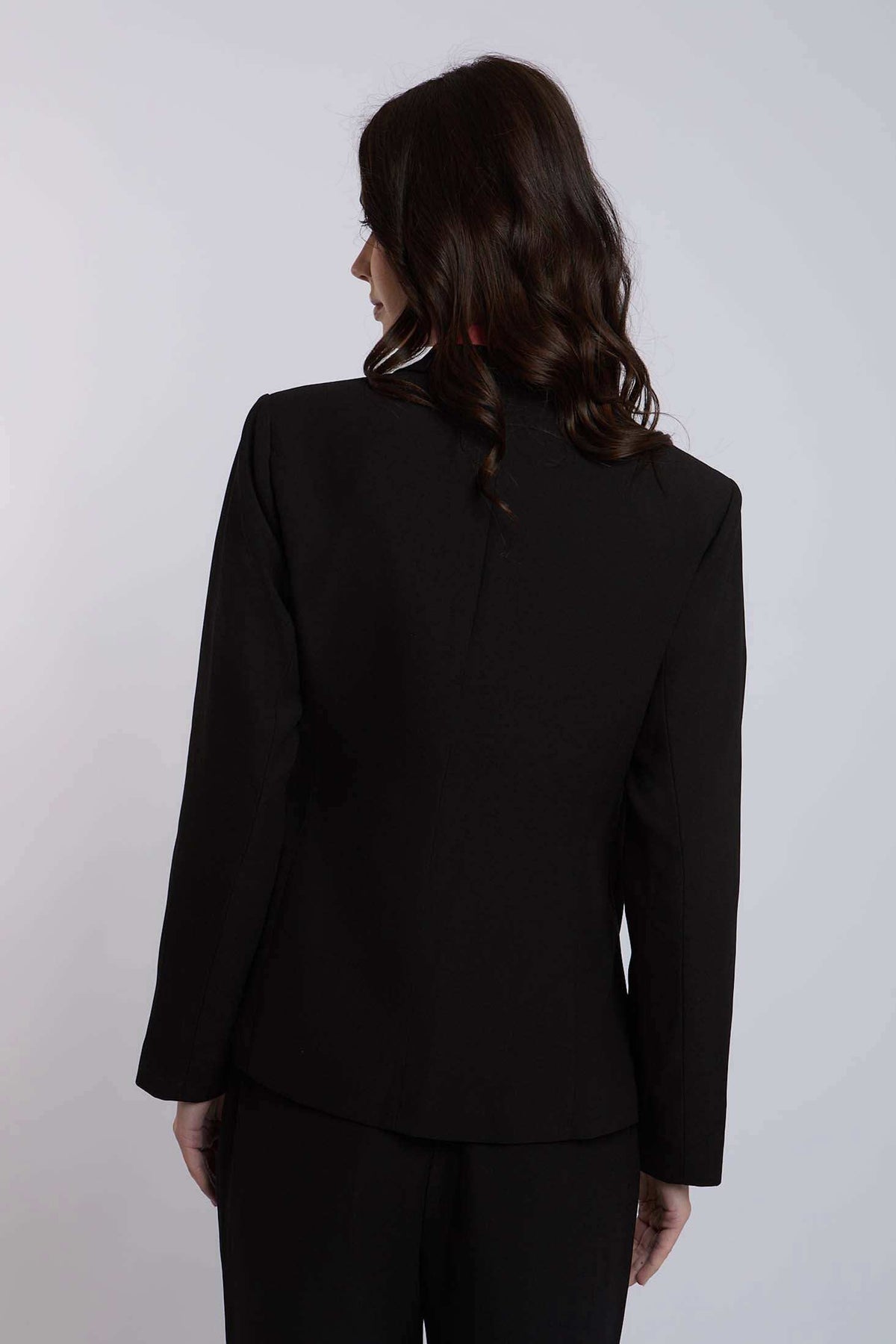 Woman in black blazer and pants, back view, formal women's fashion