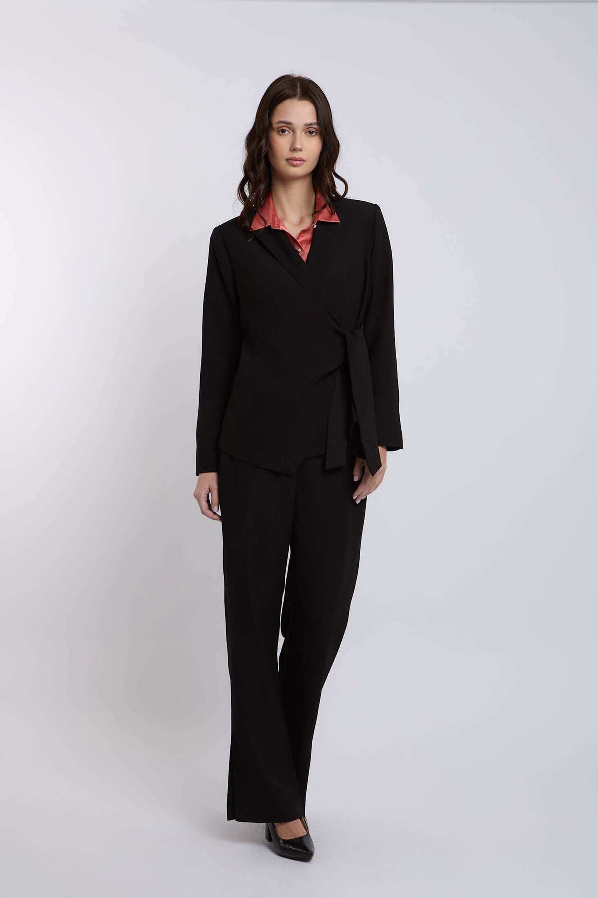Woman wearing black tailored suit with wide-leg pants and a pink collared blouse