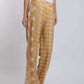 Woman wearing yellow patterned wide-leg pants and white sleeveless top