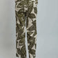 Woman wearing beige top and green leaf print wide leg pants, back view