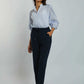 Woman wearing light blue button-up blouse with puff sleeves and navy casual pants