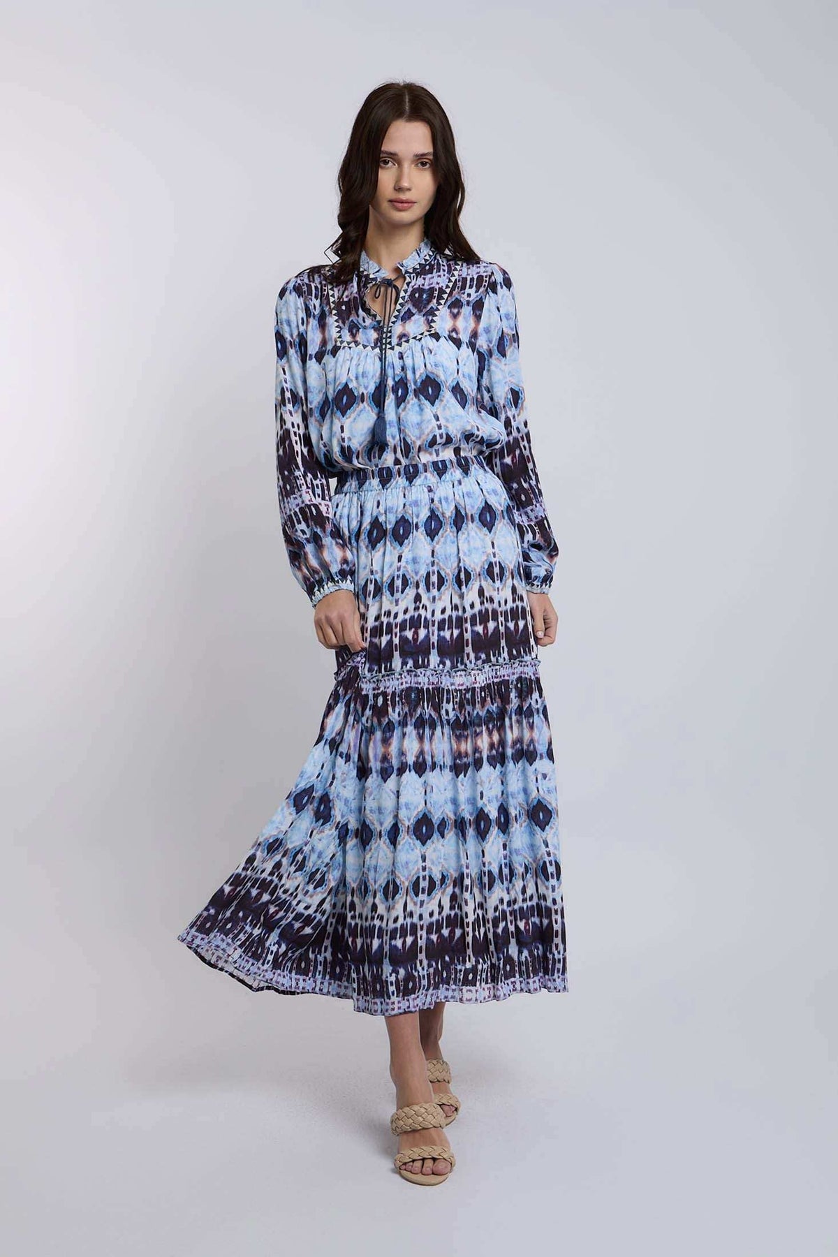 Woman wearing a long-sleeve, blue patterned maxi dress with flowy skirt