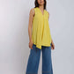 Woman wearing sleeveless yellow top with V-neck, wide leg blue jeans, and white sneakers