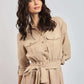 Woman wearing beige belted shirt dress with long sleeves and front button closure