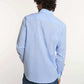 Man wearing light blue Dalydress men's shirt and blue jeans, back view, on white background