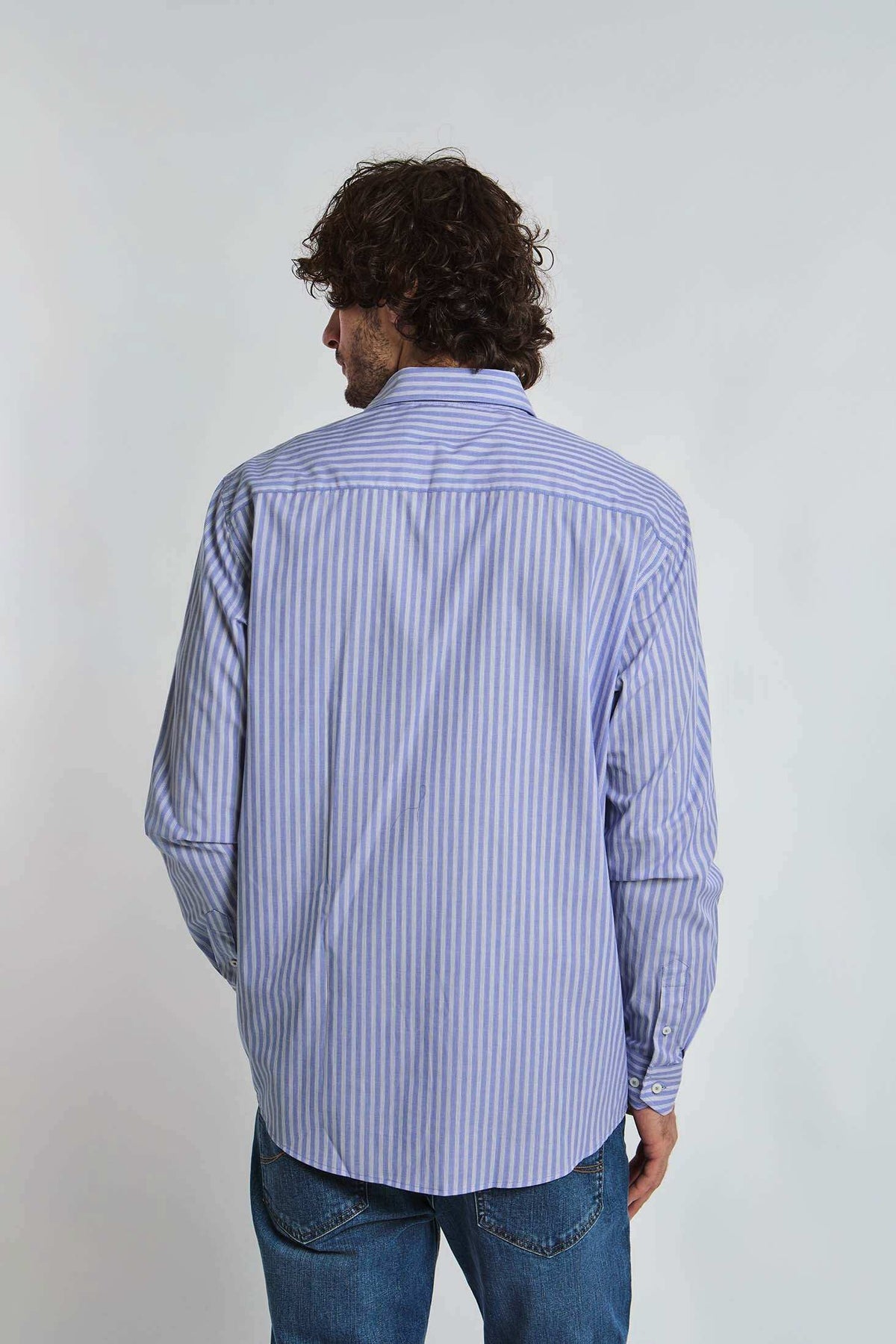 Man in blue and white striped Dalydress shirt and jeans, back view, casual men's fashion