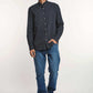 Man modeling Dalydress men's navy polka dot shirt with blue jeans and white sneakers
