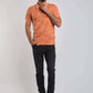 Man wearing an orange leaf-patterned polo shirt, black jeans, and white sneakers