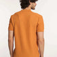Man wearing textured orange short sleeve polo shirt and blue jeans, back view