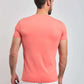 Man wearing coral short sleeve t-shirt and white pants, viewed from the back