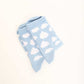 Light blue socks with white cloud pattern on plain background
