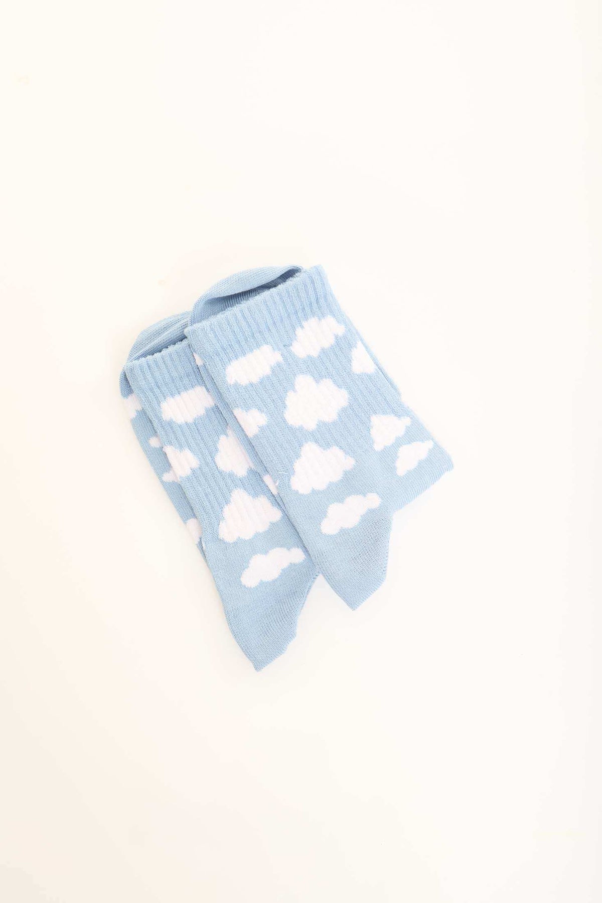 Light blue socks with white cloud pattern on plain background