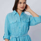 Woman wearing light blue belted long sleeve shirt dress with chest pockets