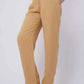 Woman wearing beige straight-leg trousers with pockets and nude heels