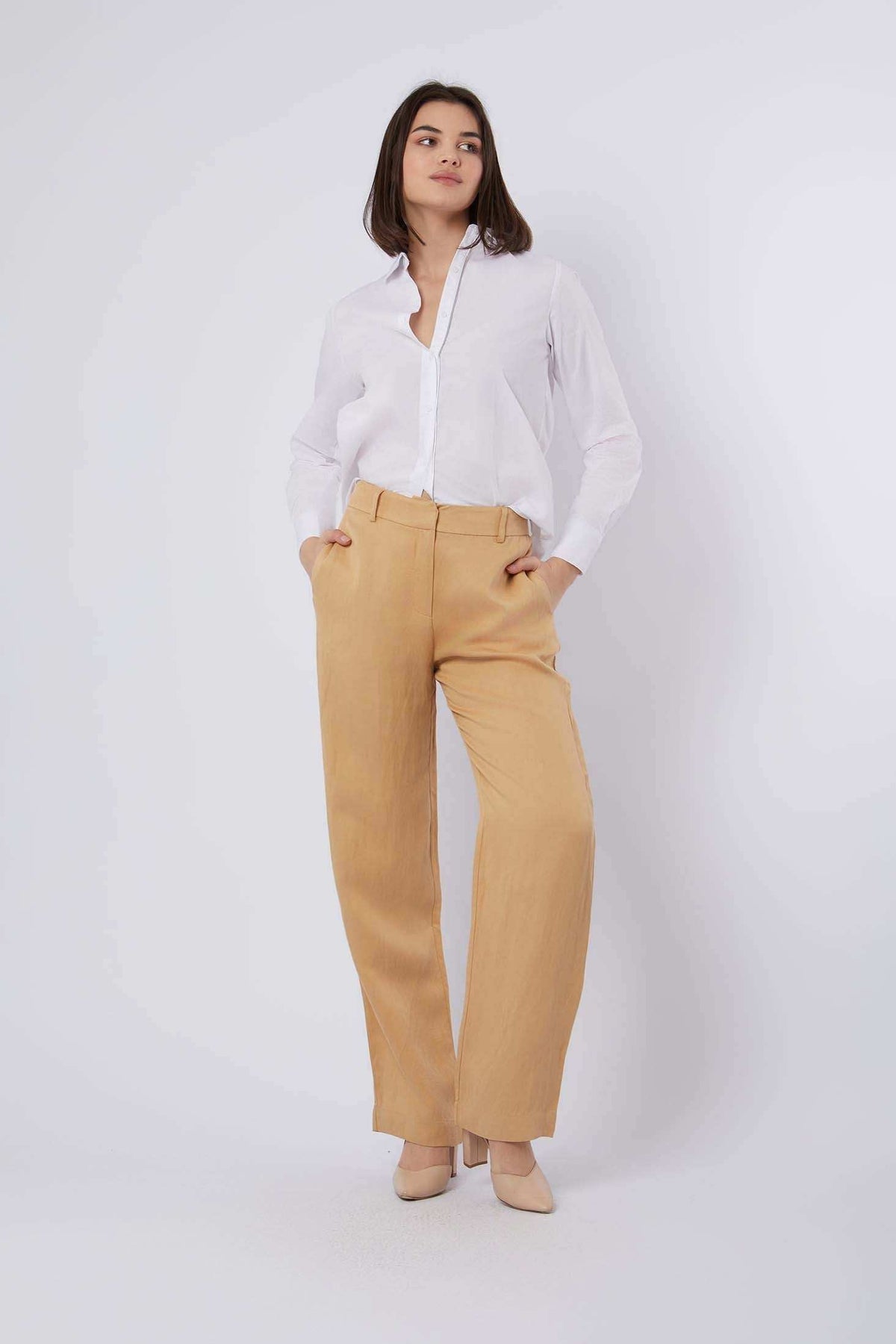 Woman in white button-up shirt and tan wide-leg pants with beige heels, casual chic outfit