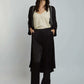 Woman wearing a cream blouse, black long cardigan, and black wide-leg trousers
