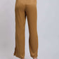 Woman wearing high-waisted mustard yellow wide-leg trousers and heeled sandals