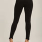 Back view of woman wearing black leggings and beige high heels against neutral background