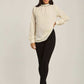 Woman modeling an off-white long sleeve blouse with black skinny pants and beige heels