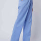 Woman wearing high waist light blue wide leg pants with side pockets and beige heels
